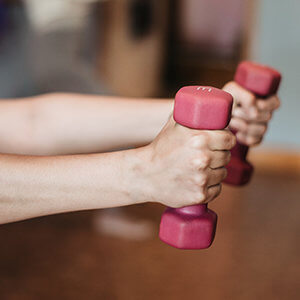 Lifting pink hand weights during an exercise physiology session